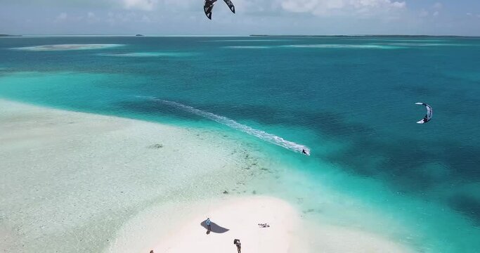 Aerial view man kitesurf in caribbean sea. Atoll with turquoise water and white sand