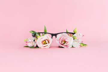Summer concept of beach sunglasses with flowers instead of glasses on a pink background. Summer vacation and enjoyment minimal concept. Woman accesory.