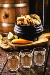 Cachaça, pinga, cana or caninha is the sugarcane brandy produced in Brazil, served with pork rinds, fried bacon, usually taken from the pork belly.