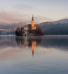Fototapeta na wymiar Sunrise at lake Bled. Beautiful soft morning colors at the lake.