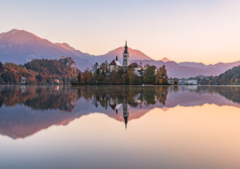Obraz premium Lake Bled at Sunrise. Church, castle and the mountains are basking in the morning sun