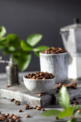 A handful of roasted coffee beans in Minsk on a grey background.