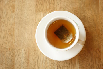 green tea with tea bag on tiles background 
