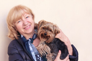 Smiling elderly lady with her little yorkshire terrier dog