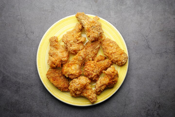 Crispy fried chicken wings on a plate top view .