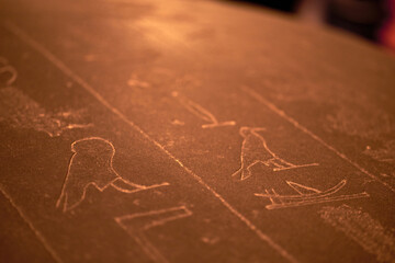 Naklejka premium Hieroglyphic carving on an ancient Egyptian sargophagus in an ancient temple, selective focus
