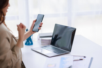 Yes, Excited happy woman looking at the phone screen, celebrating an online win, overjoyed young Asian female screaming with joy, isolated over a white blur background