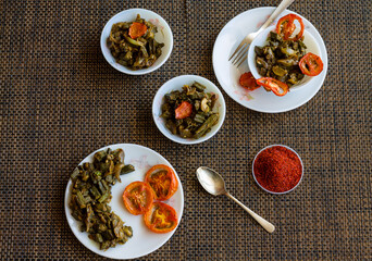 Bhindi Masala or Bharwa Bhindi Do Pyaza is diced Okra sauteed in butter,Indian spices like bay leaf,paprika,fennel and onion. This Indian vegetable is served with grilled tomato.Closeup,top view 