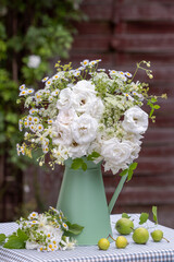 Blumenstrauß mit weißen Rosen, Wildastern und Wilden Möhren im vintage Krug