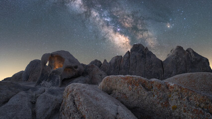 Rocky formations on mountain under starry sky in twilight