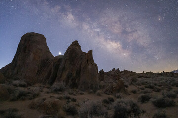 Rocky formations on mountain under starry sky in twilight