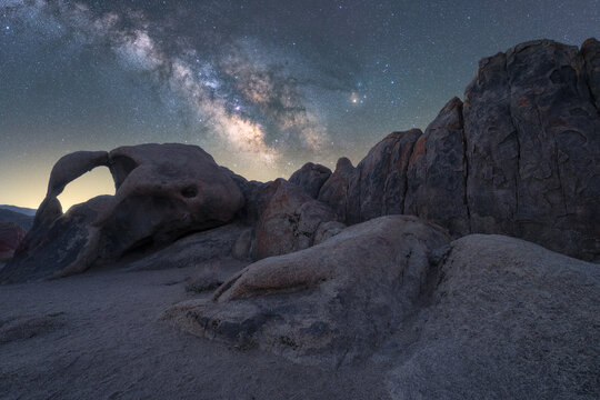 Rocky formations on mountain under starry sky in twilight