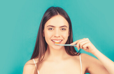 Smiling young woman with healthy teeth holding a tooth brush. Young beautiful girl holding a...