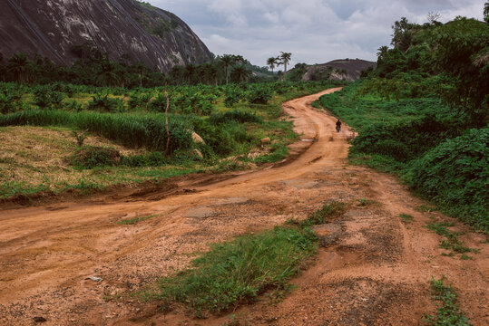 An untarred road by a rocky hillside in Ikere Ekiti - path in the mountains