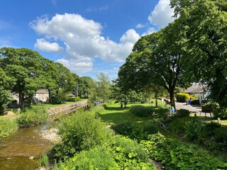 View over the, River Aire, with wild plants and trees nearby, as it flows gently through Gargrave, UK