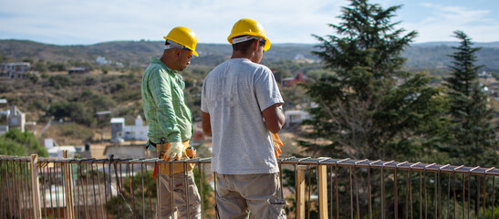 bricklayers with yellow helmet and protective glasses building an iron beam for reinforced concrete - PHOTO SESSION: WORK IN CONSTRUCTION