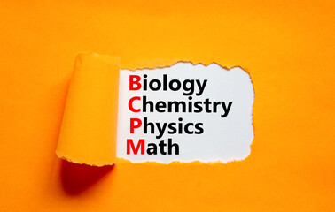 BCPM biology chemistry physics math symbol. Concept words BCPM biology chemistry physics math on white paper on beautiful orange background. Business BCPM biology chemistry physics math concept.