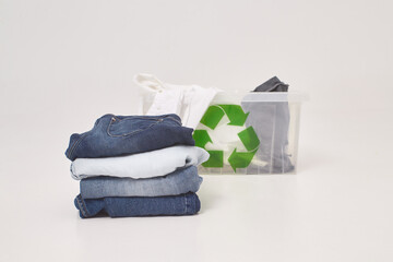 second-hand clothing or recycling, ecology concept, jeans, t-shirt, pants are gathered in a pack on a white floor