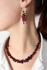 Luxurious vintage garnet jewelry set on the girl: necklace and earrings. Fashion antique jewelry.