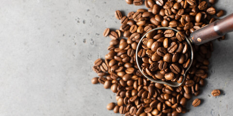 Turk with roasted coffee beans and grains around on a gray background. Copy space.