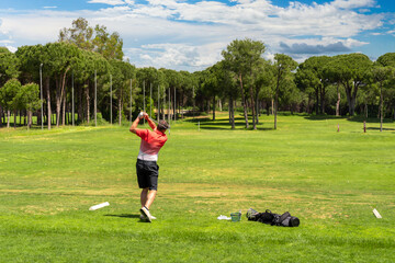 Man training golf skills on a driving range on golf course