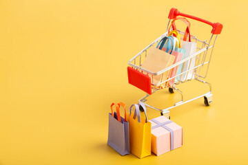 Trolley cart with colorful paper shopping bags isolated. Creative idea for shopping online, sale,...