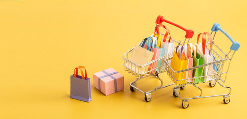Trolley cart with colorful paper shopping bags isolated. Creative idea for shopping online, sale, supermarket, discount promotion and summer sale concept.