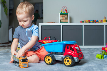 Toddler boy plays in playroom with educational toys...