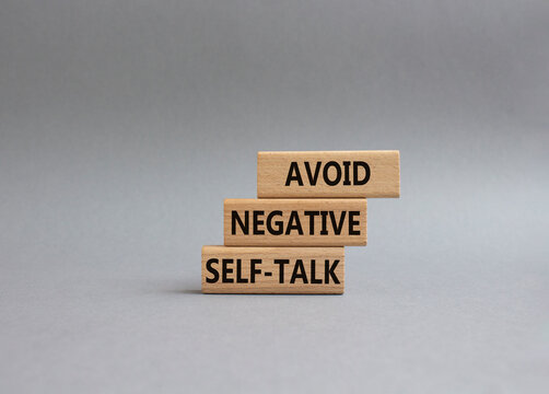 Avoid negative self-talk symbol. Concept words Avoid negative self-talk on wooden blocks. Beautiful grey background. Business and Avoid negative self-talk concept. Copy space.