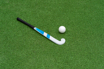 Field hockey stick and ball on green grass. Horizontal sport theme poster, greeting cards, headers,...