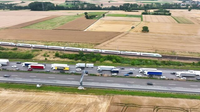 Wallau, Germany - June 29, 2022: Traffic jam on German highway A3 next to high speed train tracks nearby Wiesbadener Kreuz - aerial view