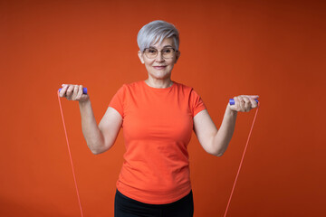 stylish woman in glasses goes in for sports with a skipping rope - obrazy, fototapety, plakaty