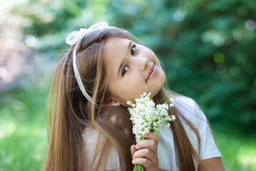 Beautiful little girl with lilies of the valley