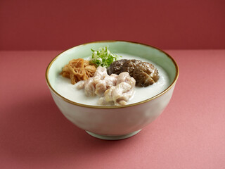 sliced chicken and mushroom congee served in a dish isolated on mat side view on grey background