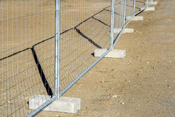 Temporary metallic portable fence with concrete base blocks to limit the territory