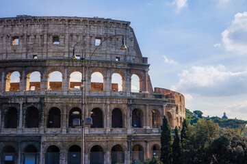 Front view of ancient Colosseum landmark of Rome, Italy, on a sunny and partly cloudy summer day.