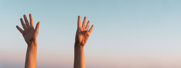 Woman hands showing or doing number nine gesture on blue summer sky background. Counting down, nine...