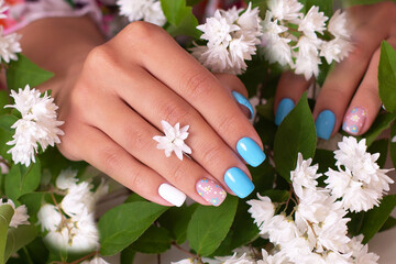 
Female hands with summer manicure nails, decorated with camomile flowers
