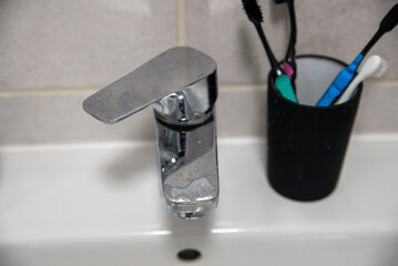 hard water residue and toothpaste dirt on the bathroom tap