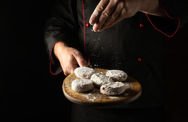 The chef sprinkles flour on cutlets on a cutting board. Preparing meat patties for a burger. Menu for a restaurant or hotel