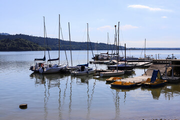 BRZEZIE, POLAND - JUNE 23, 2022: Sail boats by the wooden pier at the Czorsztynskie Lake in Poland.