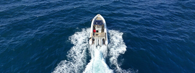 Aerial drone ultra wide photo with copy space of luxury rigid inflatable speed boat cruising in...