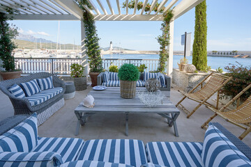 Outdoor restaurant interior with striped pillows and sea view