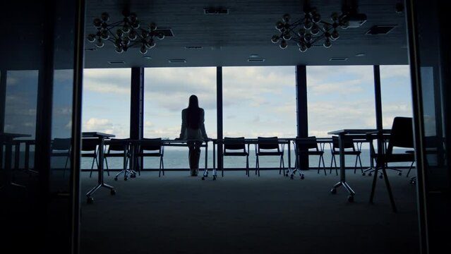 Worker silhouette resting office at sea closeup. Company intern looking window