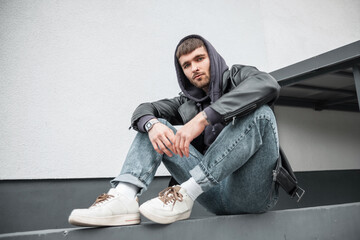 Fashionable handsome young hipster man wearing trendy clothes with jacket, hoodie, jeans and...