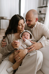 Mother and father holding their infant in minimalism interior small cute baby and stylish family with modern look
