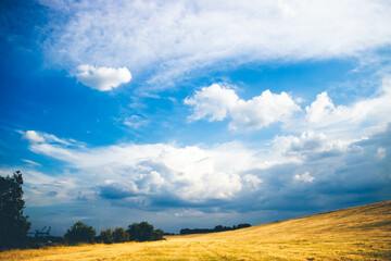 Fototapeta na wymiar Aufziehende helle und dunkle Wolken auf blauem Himmel im Sommer