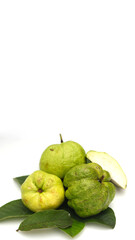 a group of fresh ripe Crystal guava (Psidium guajava) on green leaves isolated on white background.
