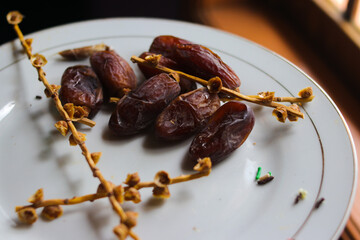Close-up view of ripe date palm fruit on white plate is ready to eat