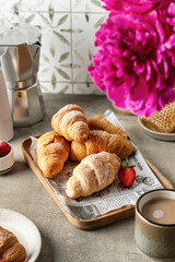 Breakfast with croissants, coffee, strawberries, peonies flower, honey composition with tile background